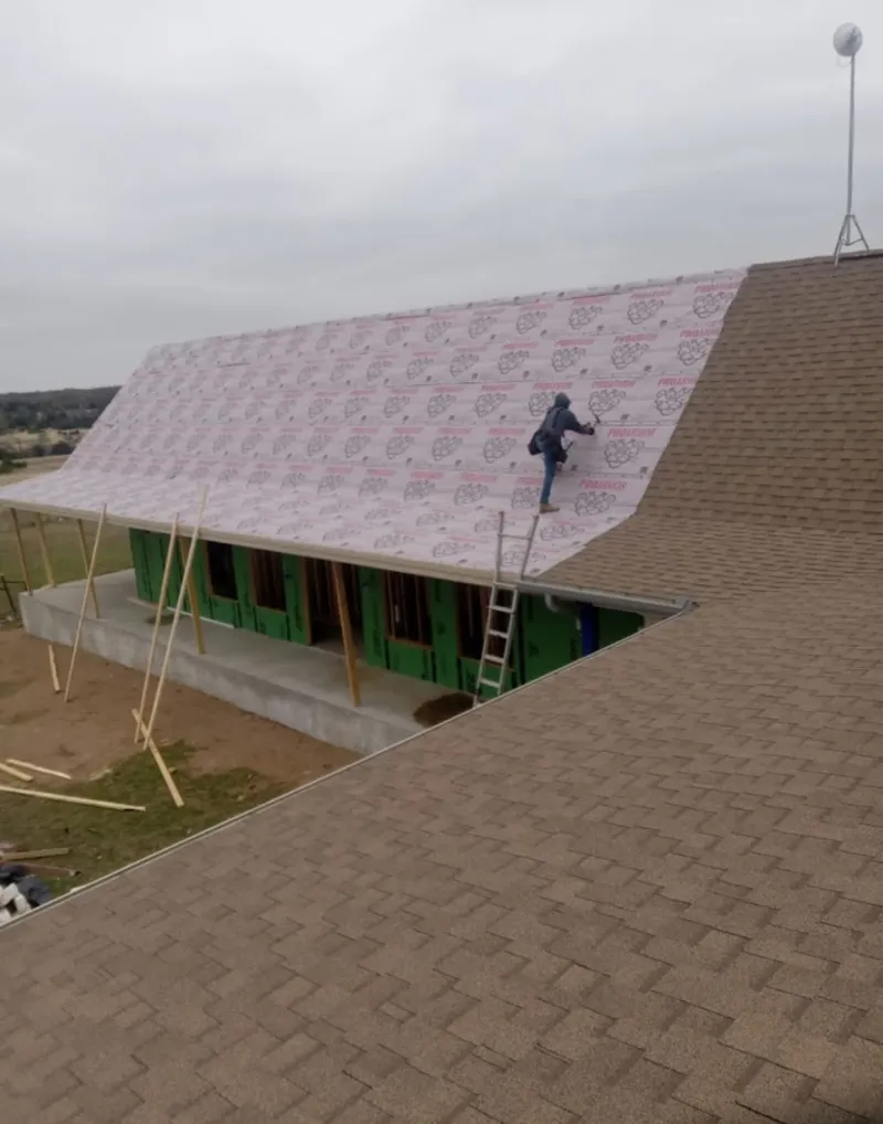 Worker preparing underlayment for a metal roof installation in Pearl City